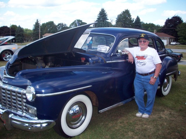 Bill McKenzie poses with his award winning Dodge at a Car Show